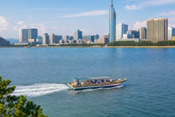 博多湾を進む観光船と福岡の街並みを表したイメージ