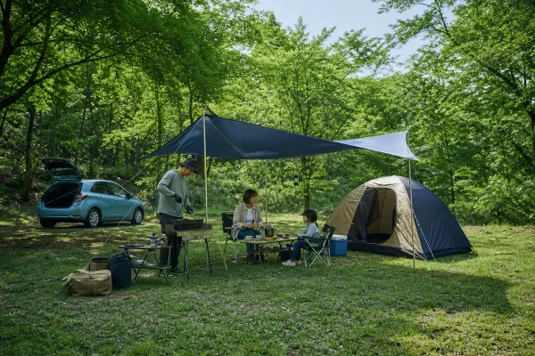 福岡の林間でテントとタープを設営し家族で屋外料理を楽しむデイキャンプのイメージ