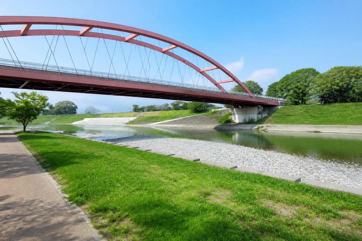 筑後広域公園の川と赤いアーチ橋を望む筑後市の案内イメージ
