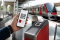 スマートフォンに表示したQRチケットを駅の改札へかざして列車に乗るイメージ