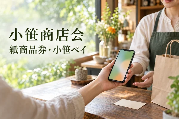 小笹の紙商品券と小笹ペイを案内する、スマートフォンと買い物袋のイメージ。実在店舗・公式アプリの写真ではありません。