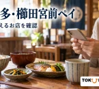 博多・櫛田宮前ペイの対象店案内を紹介する、地域の飲食店で料理を前にスマートフォンを確認するイメージ