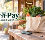 野芥Payの残高と対象店確認を紹介する、架空の青果店前の買い物袋・野菜・スマートフォンのイメージ