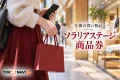 ソラリアステージ商品券を紹介する、買い物袋と画面を見せないスマートフォンを持つ手のイメージ。実在施設の写真ではありません。