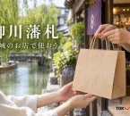 柳川藩札を紹介する、買い物袋と水路沿いの街角のイメージ。実在店舗や公式券面の写真ではありません。